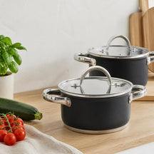 Cooking Pannenset Zwart 4-delig: twee mat zwarte kookpannen met glazen deksel op een eiken werkblad