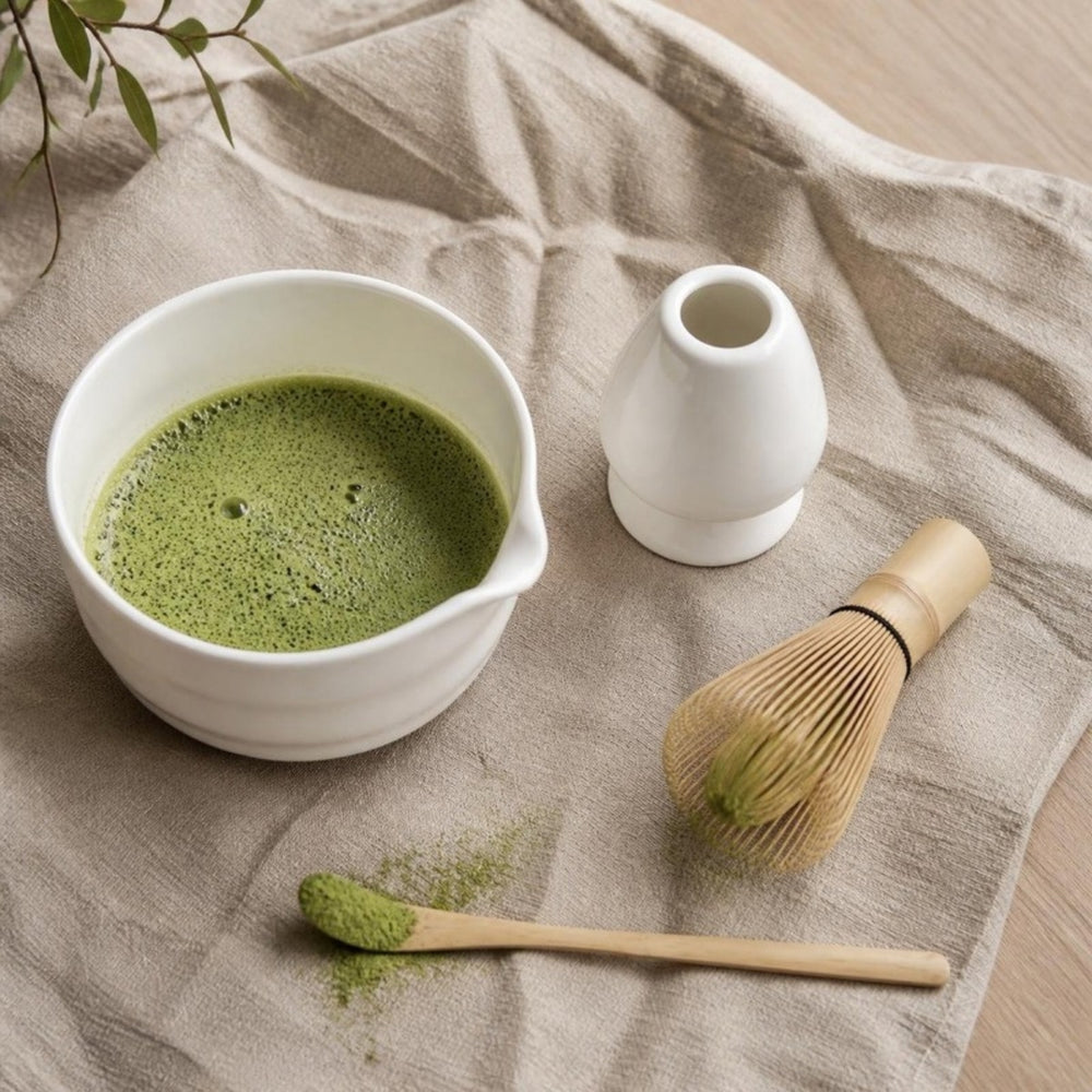 Matcha set van bovenaf: kom met matcha, garde, houder en lepel op linnen