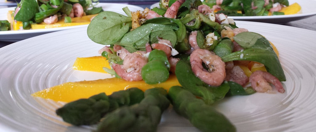 Een frisse lentesalade met groene asperges, garnalen en mango
